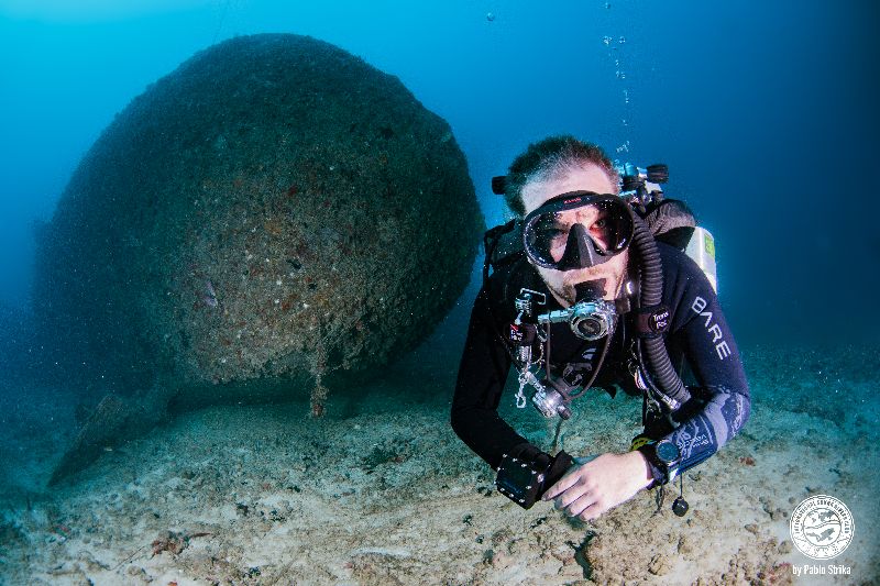 Narwal - A diver poses for the camera in front of the bow section
